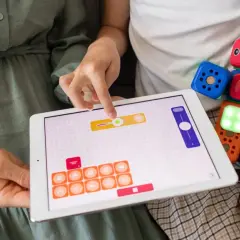 Kolorowe klocki i tablet z interaktywną aplikacją to świetne materiały do pracy z dzieckiem autystycznym, rozwijające logiczne myślenie i kreatywność.
