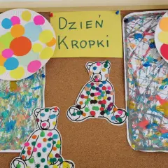 Kolorowe misie i talerzyki z kropkami ozdabiają tablicę z napisem "Dzień Kropki". Prace plastyczne pełne radości i barw.