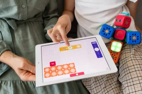 Kolorowe klocki i tablet z interaktywną aplikacją to świetne materiały do pracy z dzieckiem autystycznym, rozwijające logiczne myślenie i kreatywność.