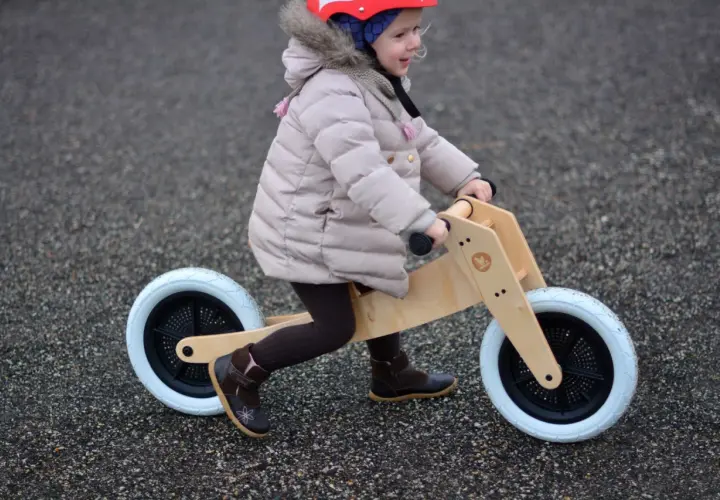 Dziecko na rowerku biegowym, ćwiczy motorykę. To świetny sposób na naukę równowagi i koordynacji.