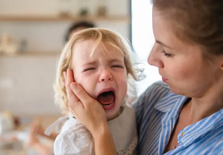 Mama pociesza płaczące dziecko, które przeżywa lęk separacyjny.