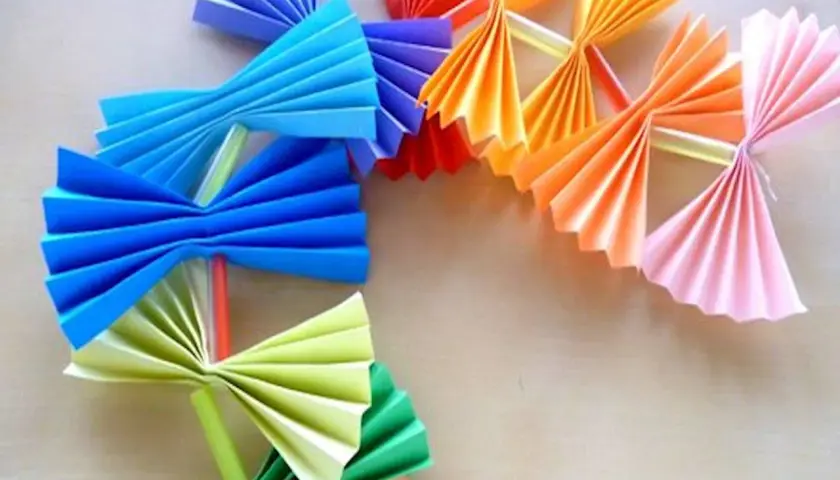 Kolorowy łańcuch choinkowy z papieru, wykonany techniką origami. Wesołe ozdoby w kształcie wachlarzy i kokardek.