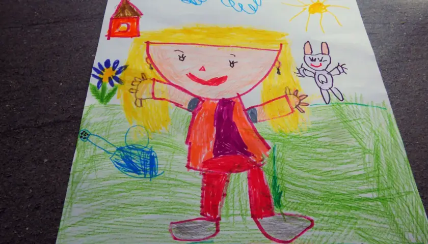 Rysunki 3 latka: uśmiechnięta dziewczynka z blond włosami, domek, słońce, chmurki, króliczek i kwiatki.