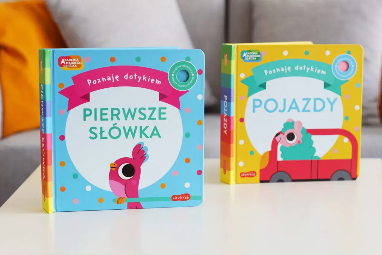 Dwie książeczki z serii Akademia Mądrego Dziecka: "Pierwsze słówka" z ptaszkiem i "Pojazdy" z uroczym stworkiem w czerwonym aucie.